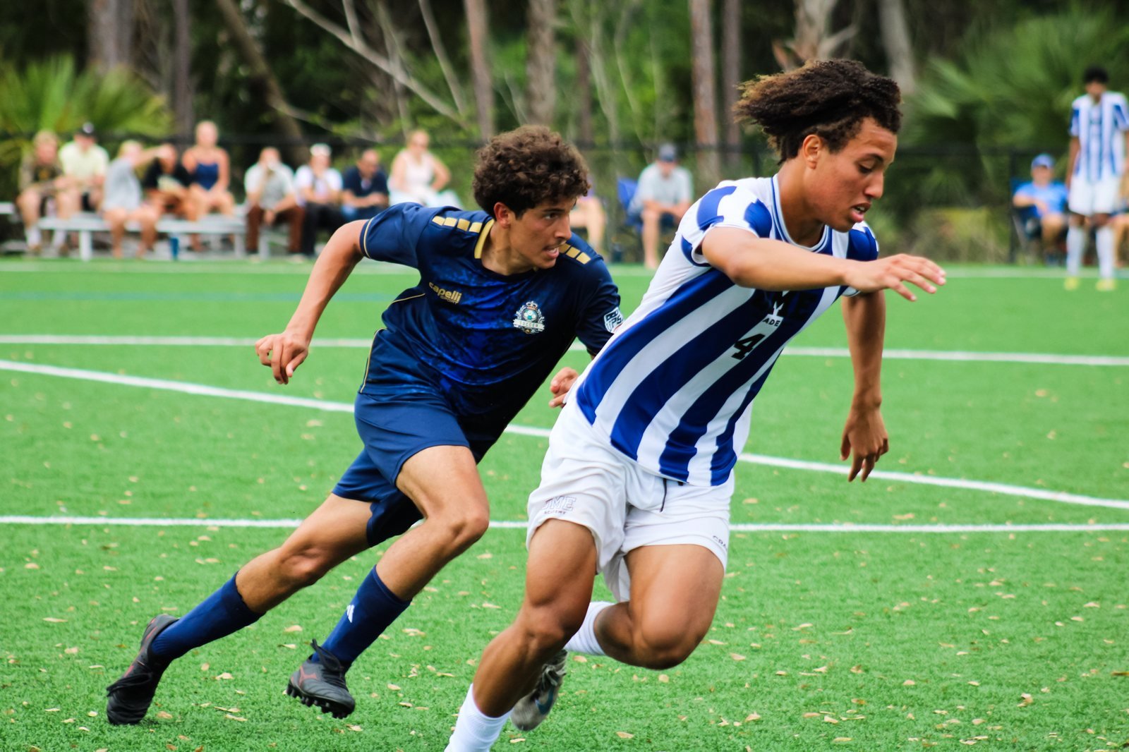 Two soccer players challenging for the ball